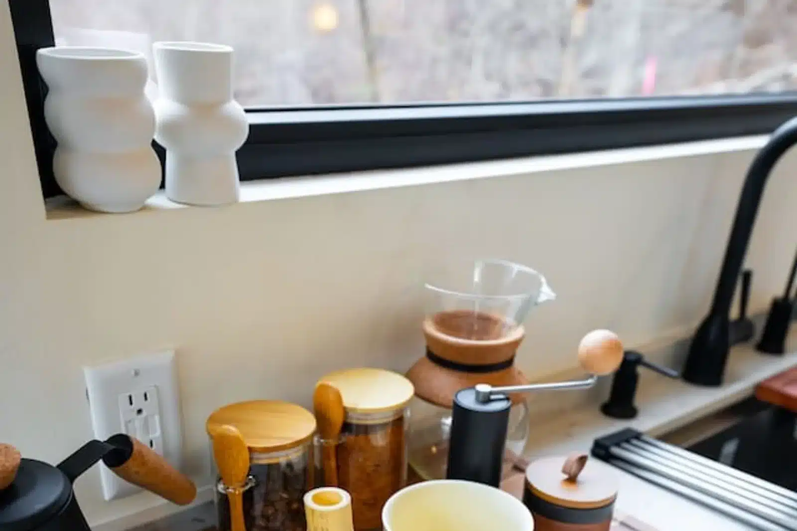 Modern kitchen countertop with white vases and organized essentials at a cabin near Shenandoah National Park