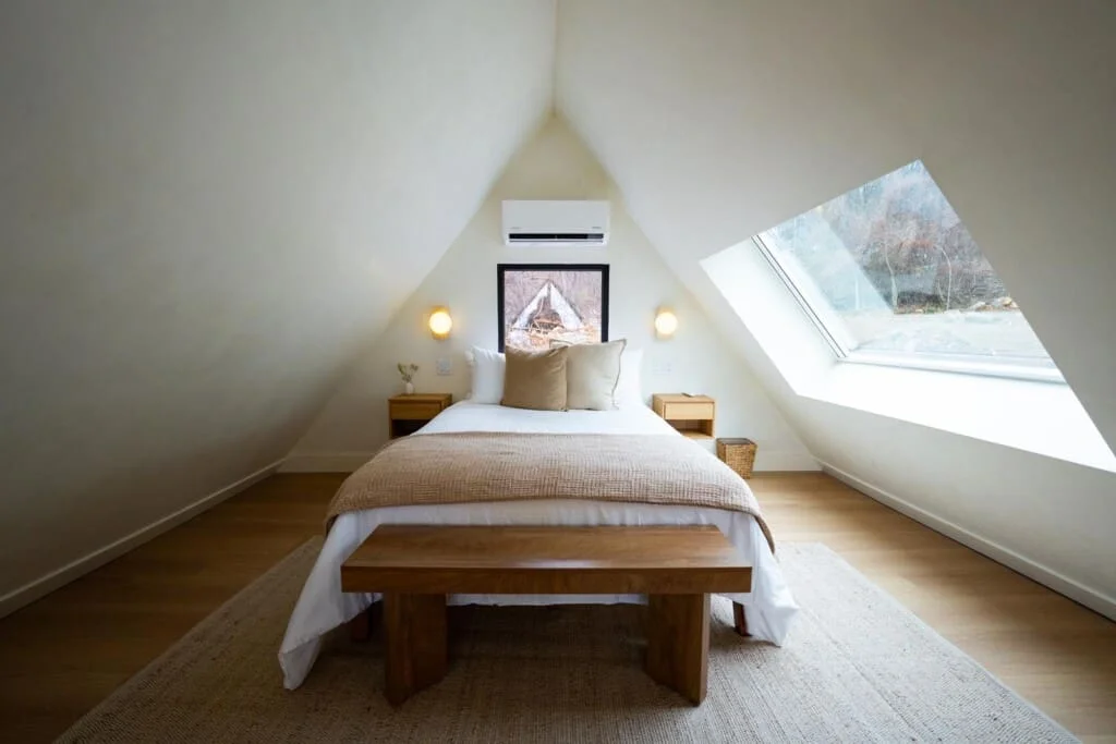 Minimalist attic bedroom with queen bed, skylight, and natural light at Royal Oak Retreat