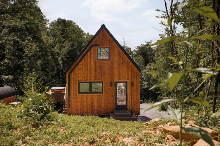 Modern A-frame cabin Virginia with wood siding nestled in forest at Royal Oak Retreat