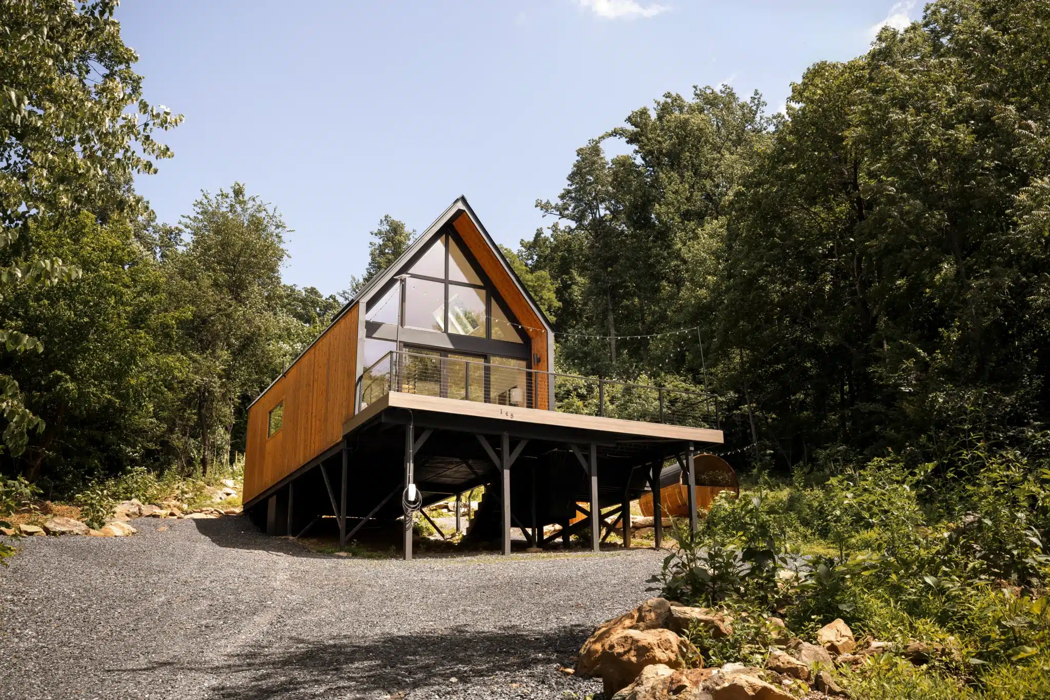 Modern retreat cabin with wood cladding and panoramic windows nestled in forest setting