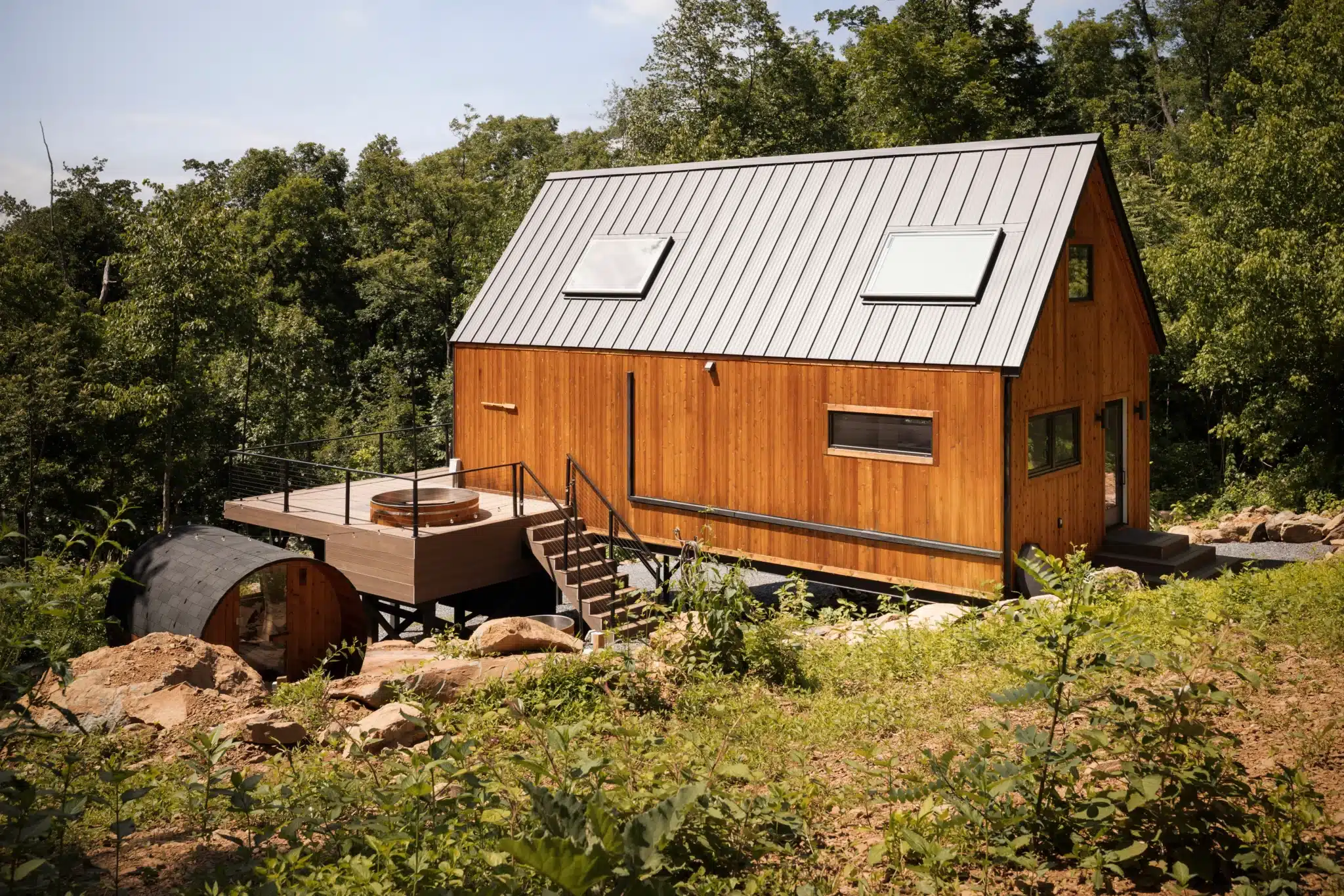 Modern cedar cabin exterior with metal roof, hot tub deck, surrounded by Shenandoah forest