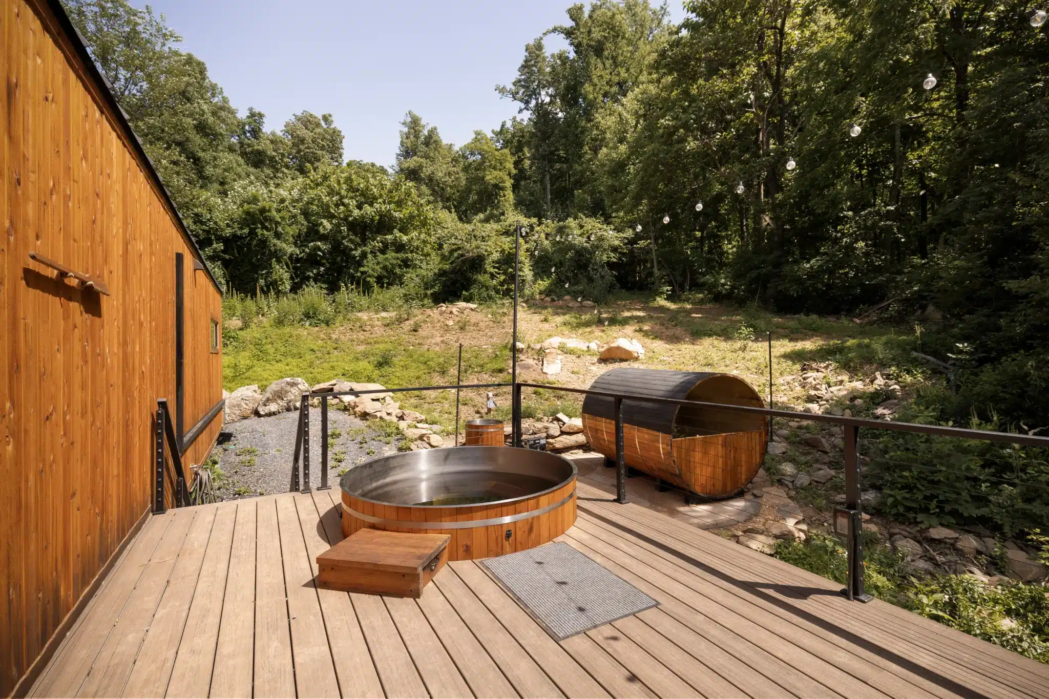 Luxury hot tub and sauna on wooden deck overlooking forest at secluded cabin Virginia