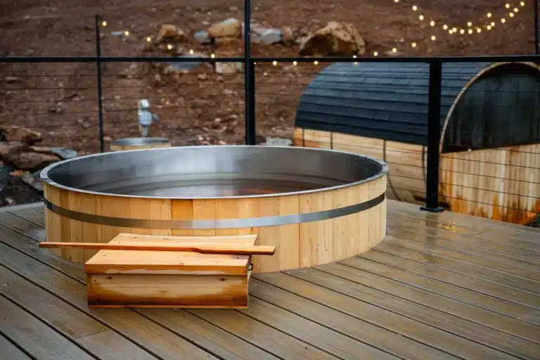 Wooden hot tub with sauna on deck at Virginia cabin vacation retreat with string lights