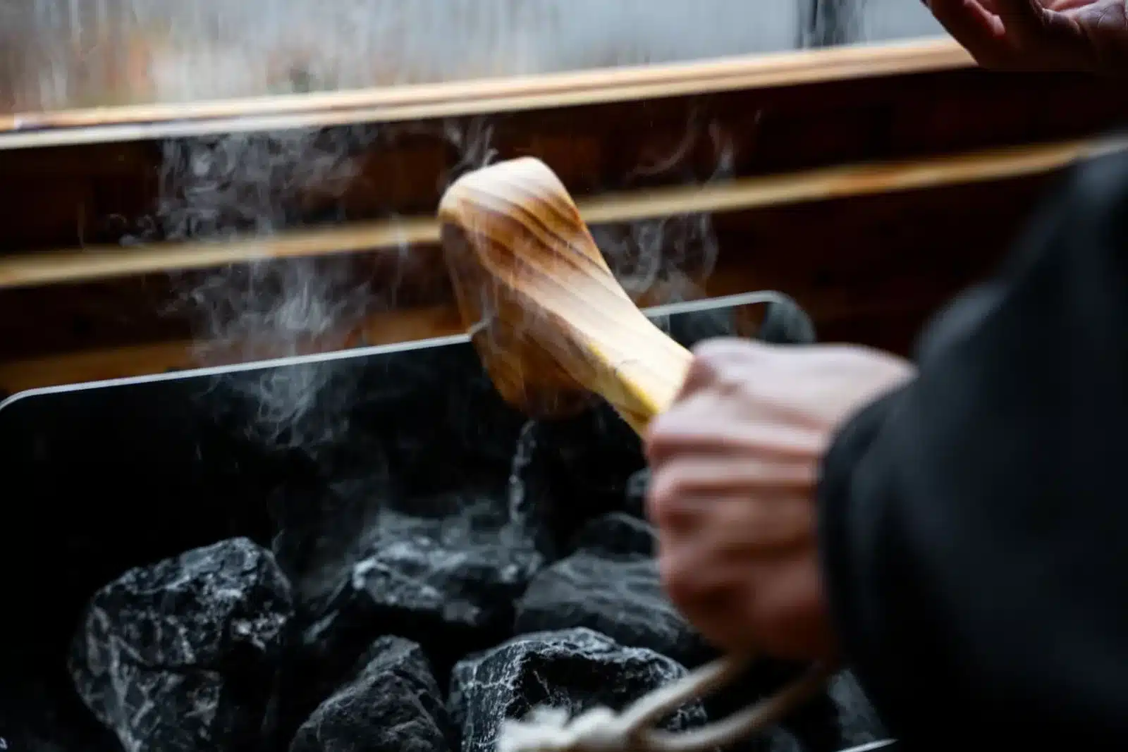 Hands tending fireplace with burning logs at dog friendly cabin in Shenandoah Valley