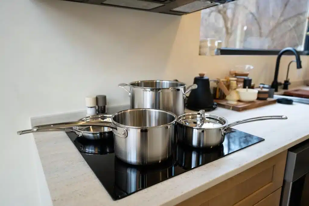 Modern kitchen with black induction cooktop and stainless steel cookware at Royal Oak Retreat