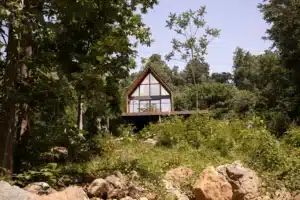 Modern treehouse vacation rental with peaked roof and elevated deck overlooking forest in Shenandoah Farms